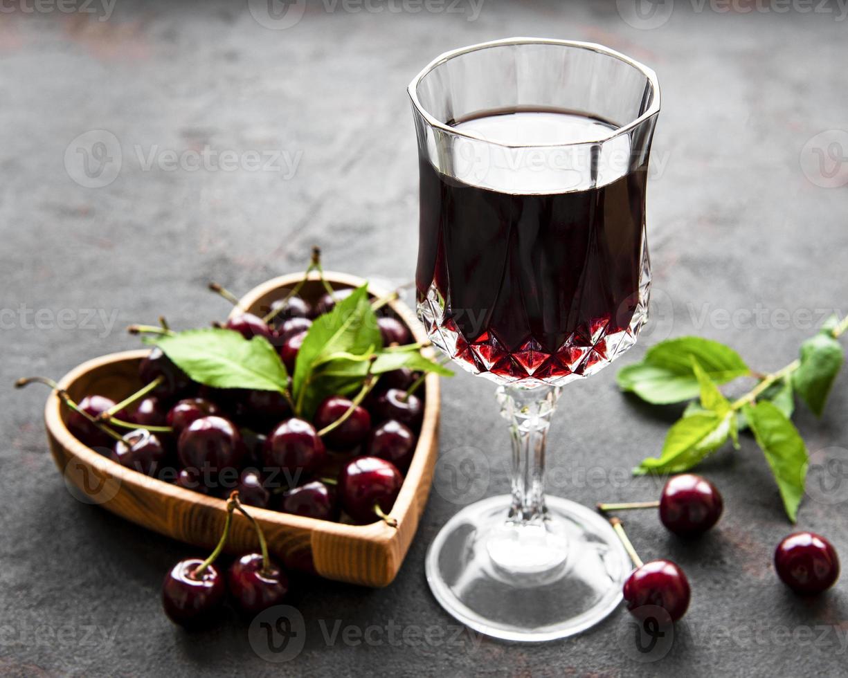 licor de cereza en un vaso y frutas frescas foto