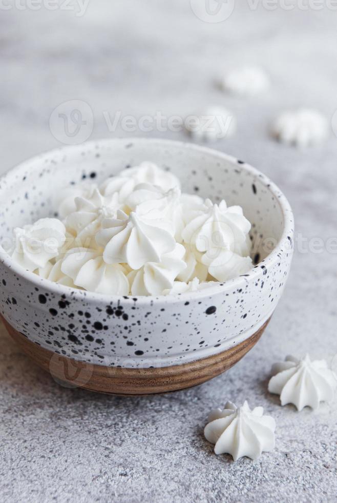 Small white meringues in the  ceramic bowl photo