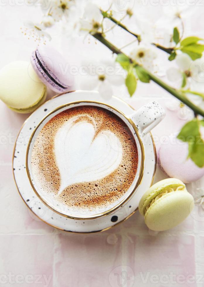 Coffee with a heart-shaped pattern and sweet macaroons desserts photo