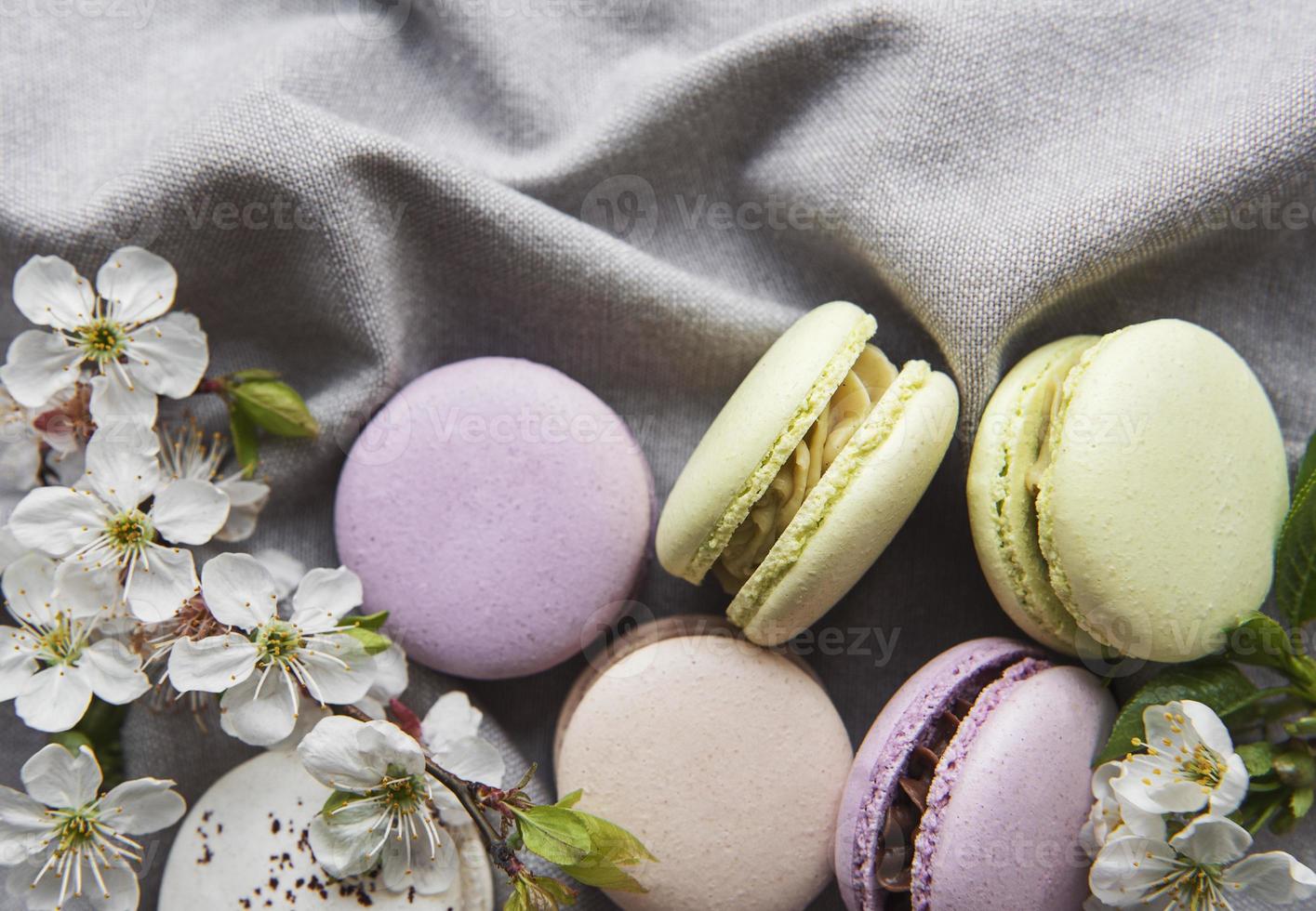 Macarrones dulces franceses variedad colorida sobre un fondo gris textil foto