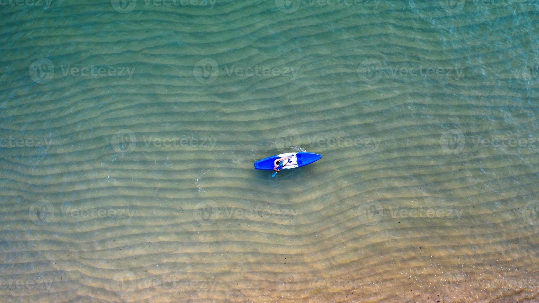 Aerial top view of kayaking around sea with shade emerald blue water and wave foam photo