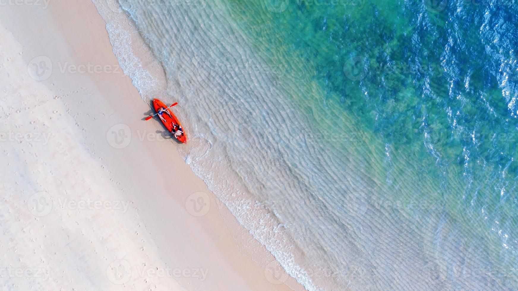 Aerial top view of kayaking around sea with shade emerald blue water and wave foam photo