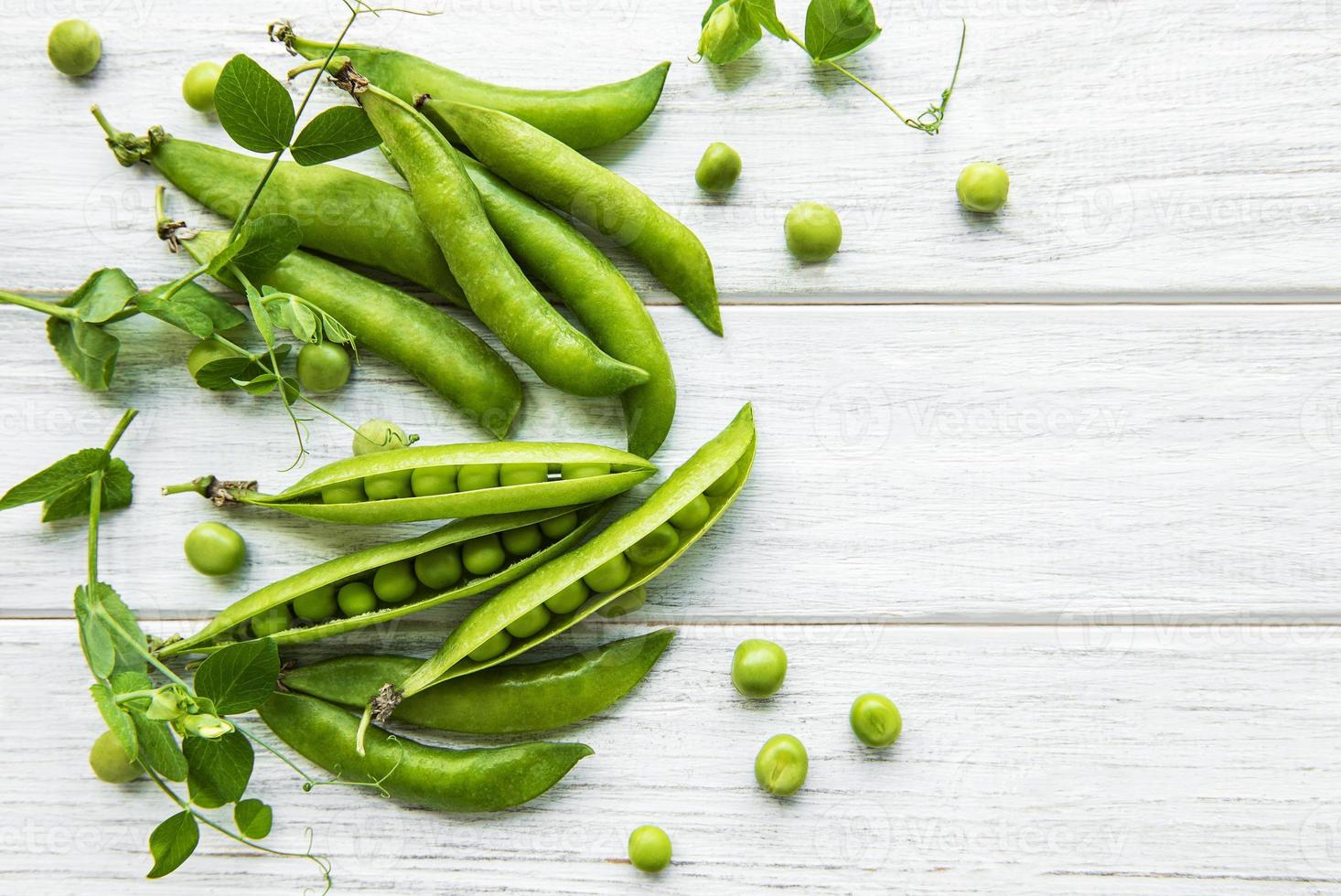 Green peas on a white wooden background.  Healthy food background photo