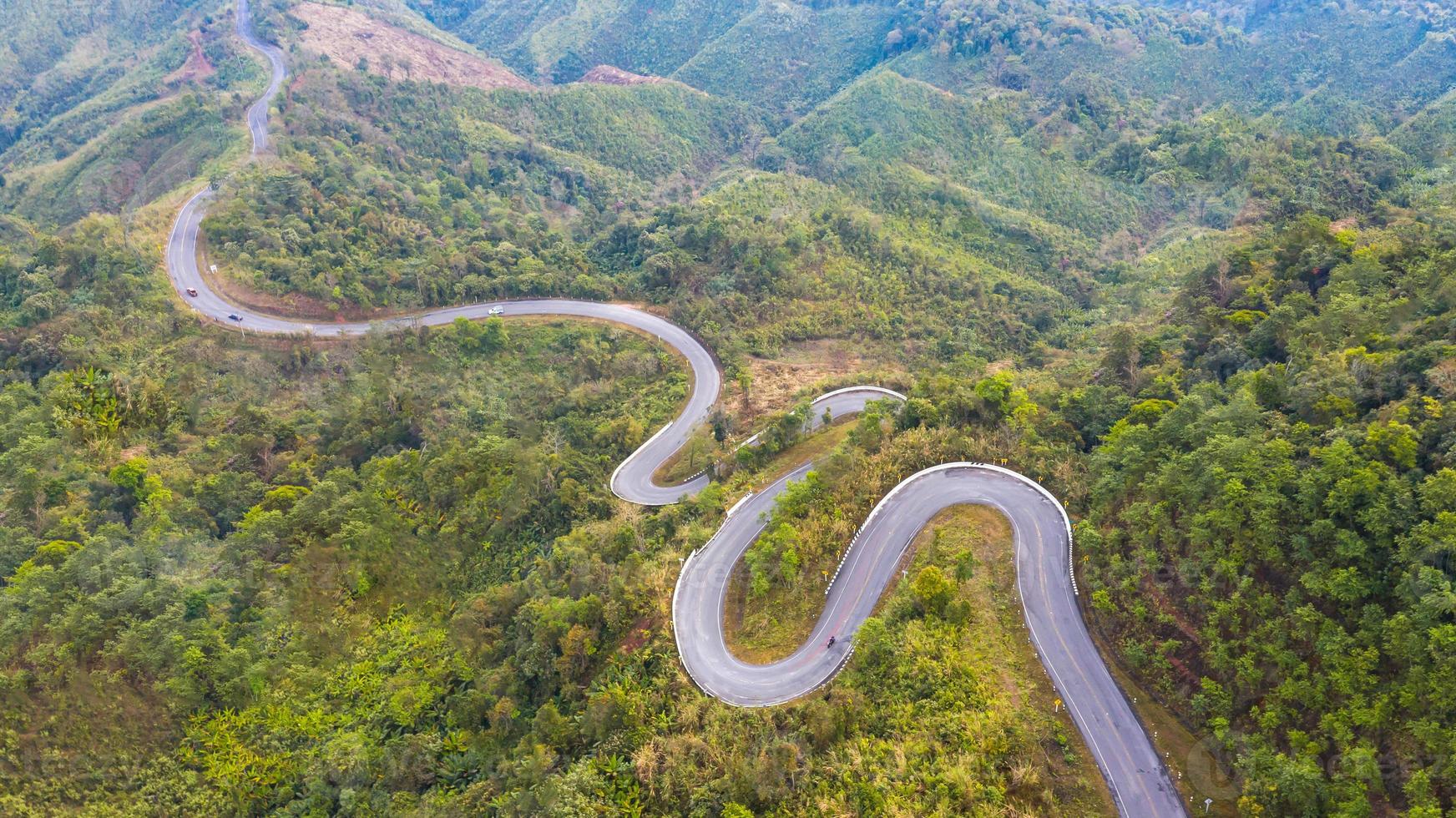 Aerial top view of a road in the forest photo