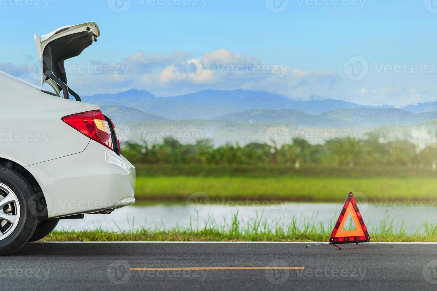 Problemas de coche y una señal de advertencia de triángulo rojo en la carretera foto