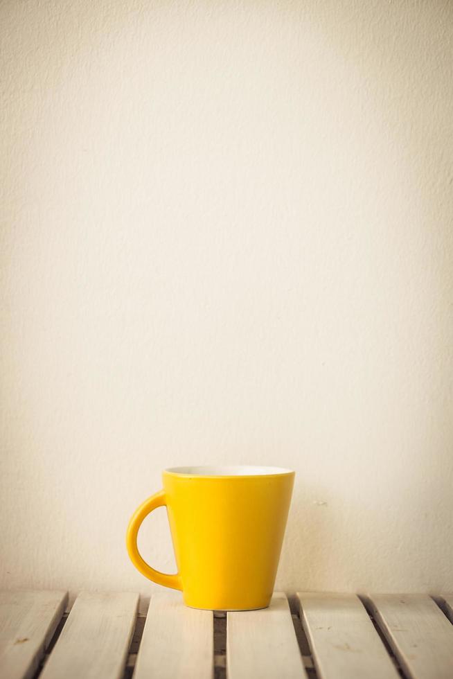 Yellow coffee cup on table photo