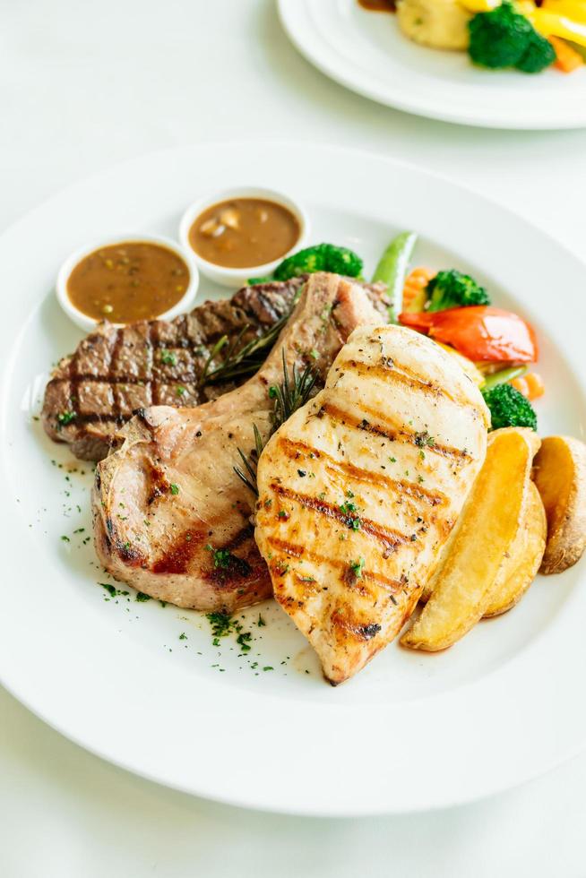 pechuga de pollo y chuleta de cerdo con filete de carne de res y verdura foto