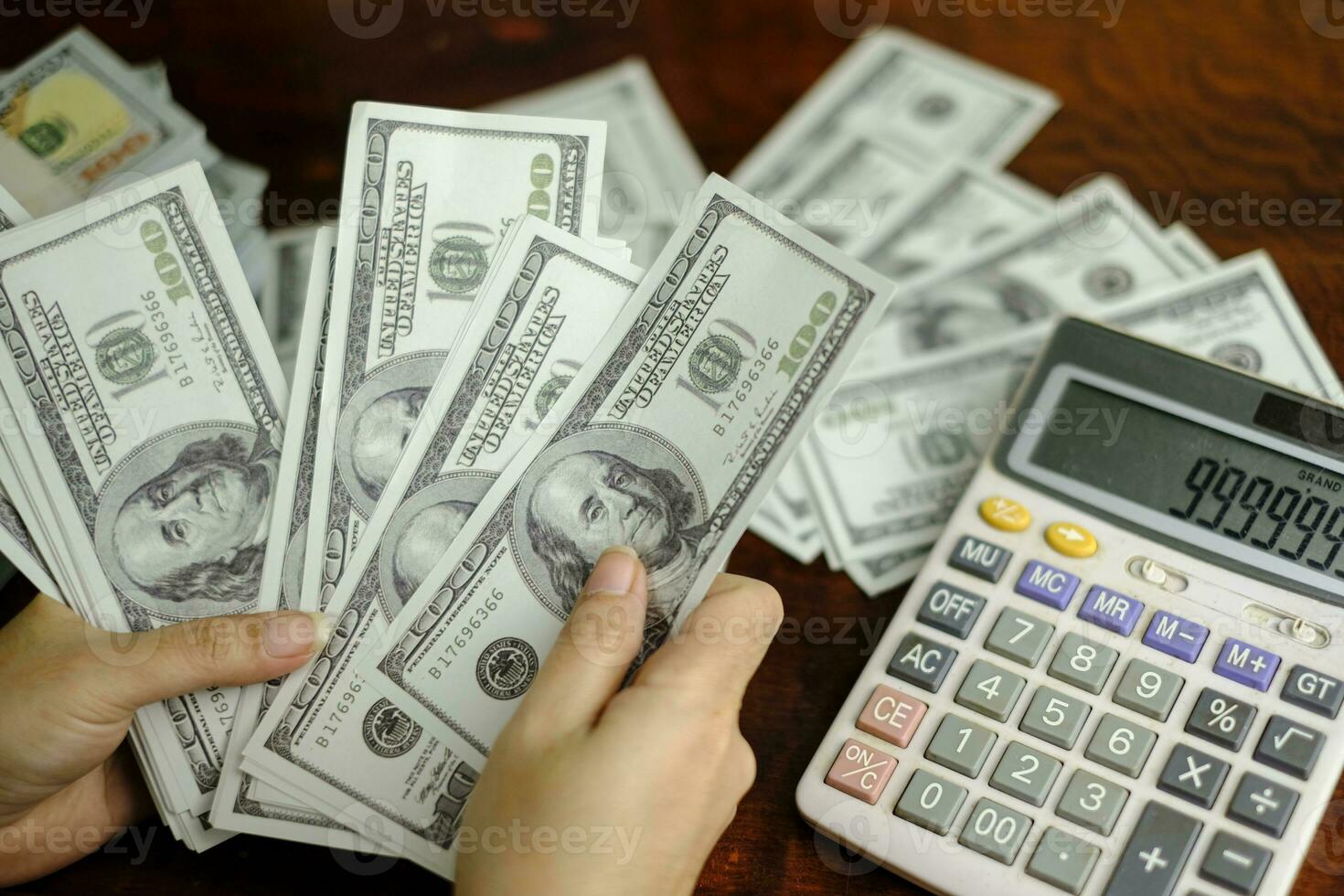 hombres de negocios mujeres contando dinero en una pila de billetes de 100 dólares estadounidenses foto