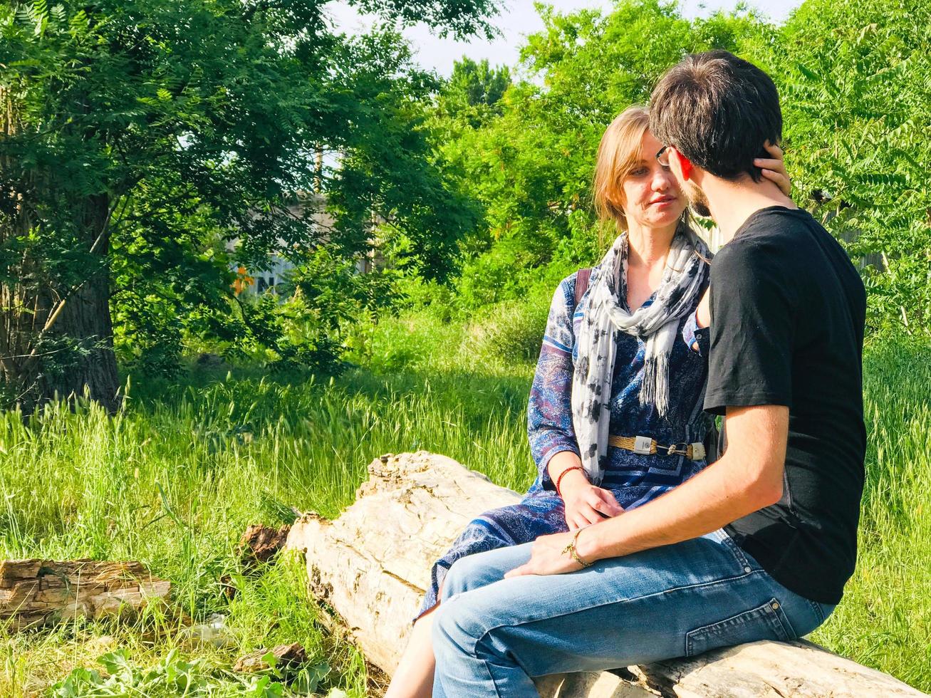 Young couple sitting on the tree branch photo