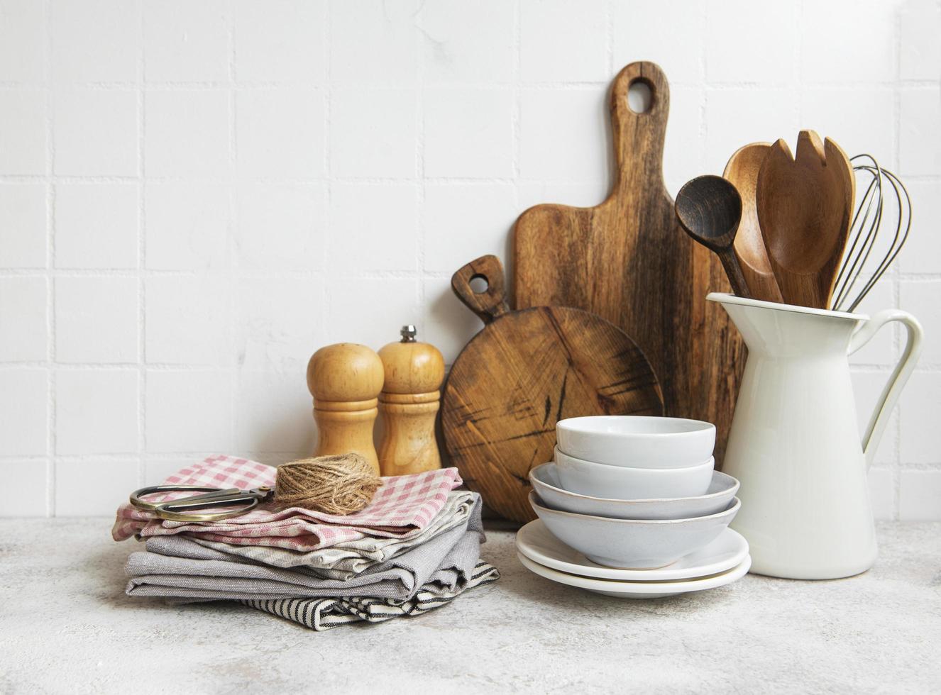 Kitchen utensils, tools and dishware on on the background white tile wall photo