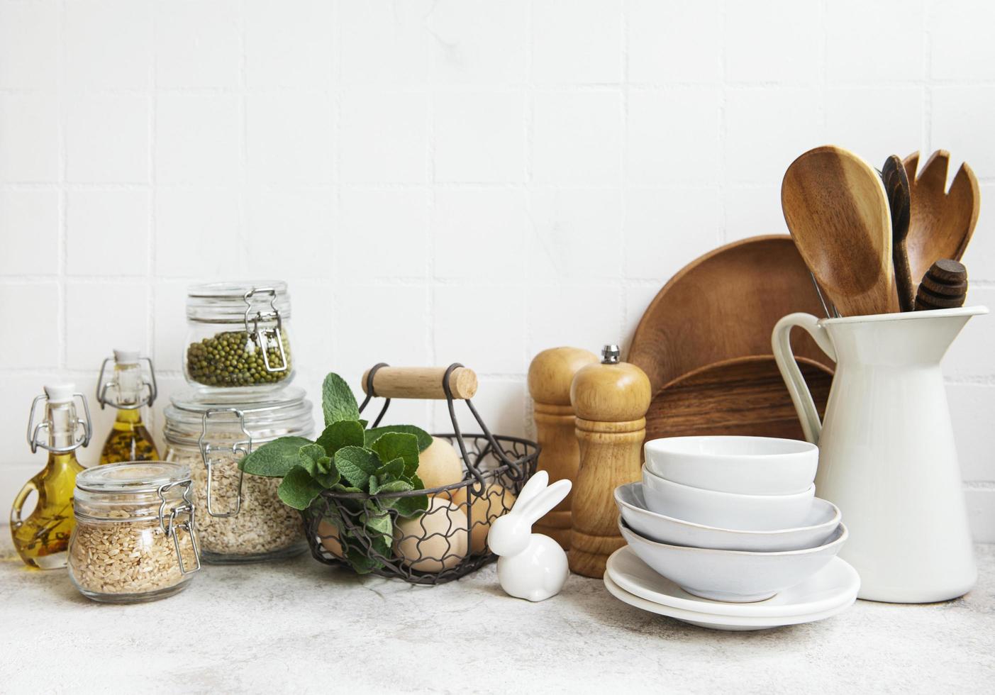 Kitchen utensils, tools and dishware on on the background white tile wall photo