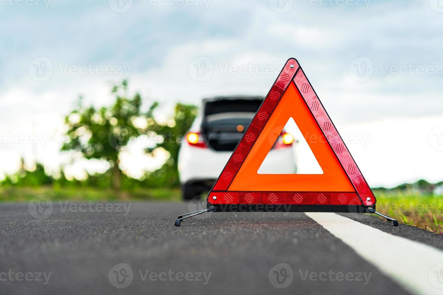 Problems car and a red triangle warning sign on the road photo