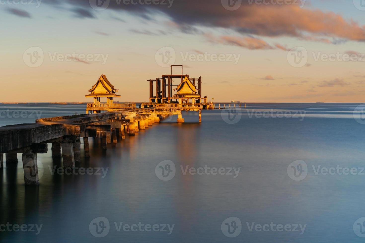 El viejo puente hacia el mar en la playa al amanecer. foto