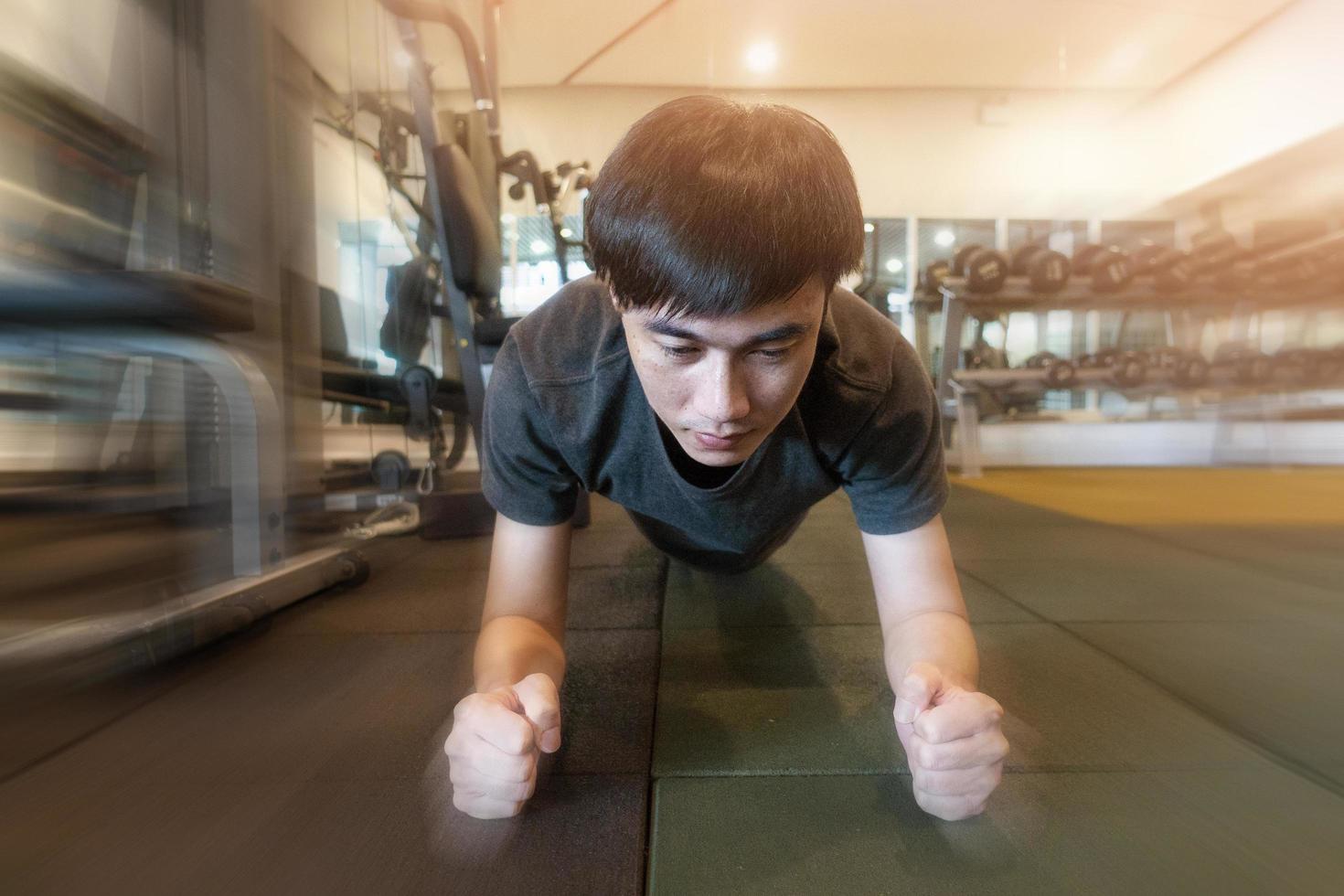 Fitness man is planking in the gym photo