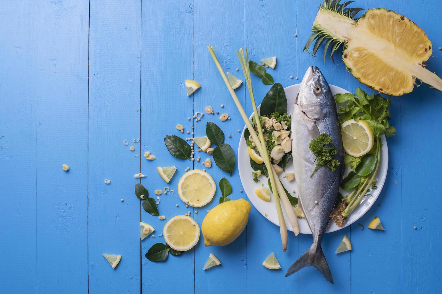 Comida de pescado con especias de ingredientes en el cuadro azul foto