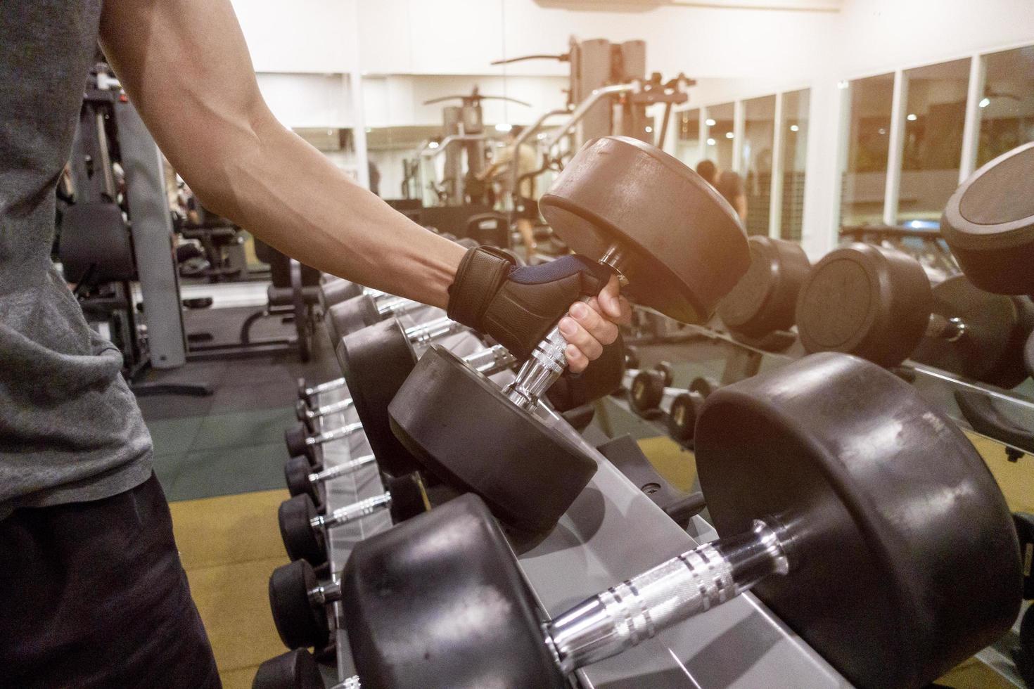 Human Hand holding dumbbell in gym photo