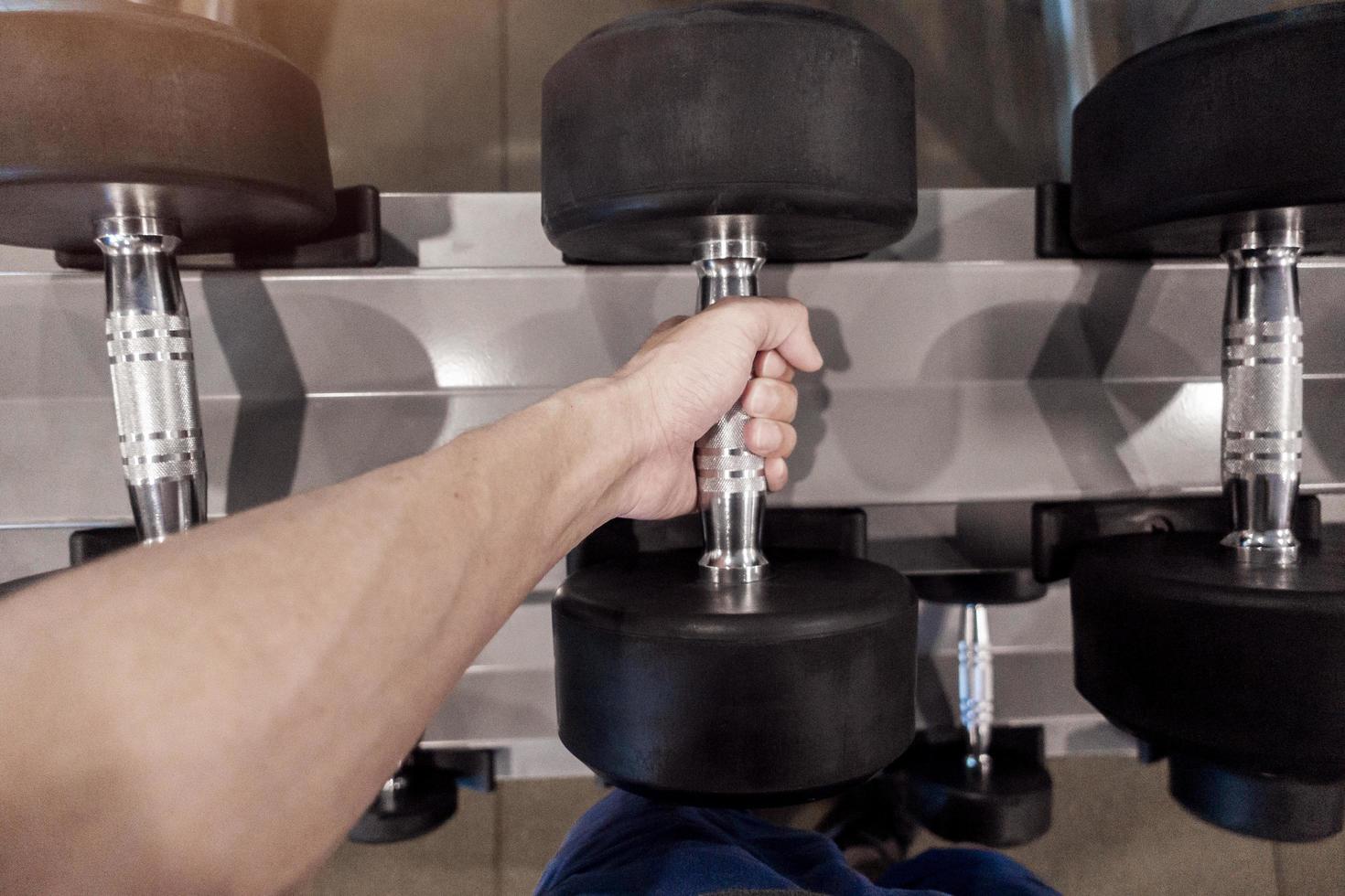 Human Hand holding dumbbell in gym photo