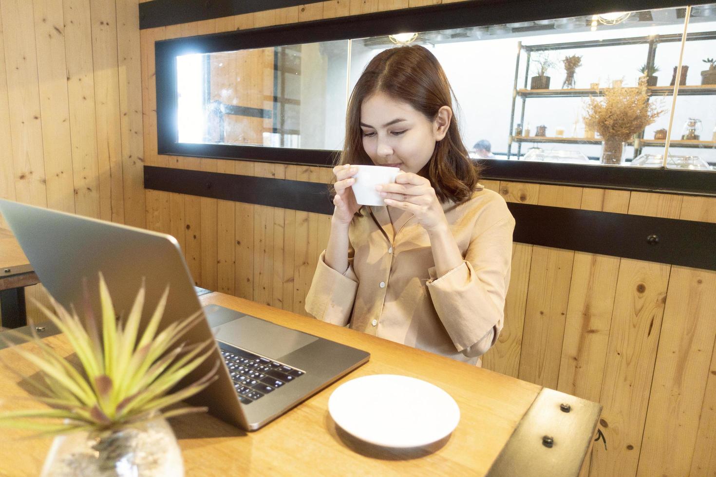 Hermosa mujer de negocios está trabajando con su computadora portátil en la cafetería. foto