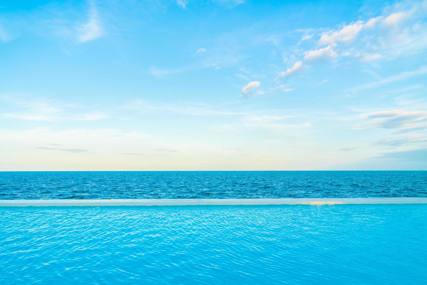 Piscina infinita con vista al mar y al océano en el cielo azul foto