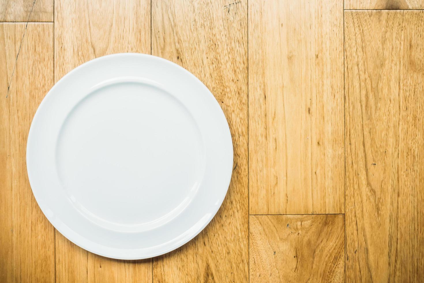 Empty white plate on wooden background photo