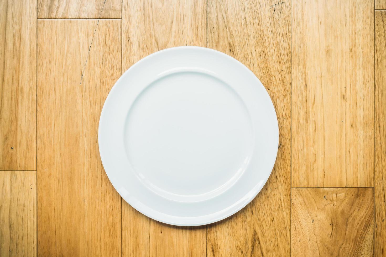Empty white plate on wooden background photo