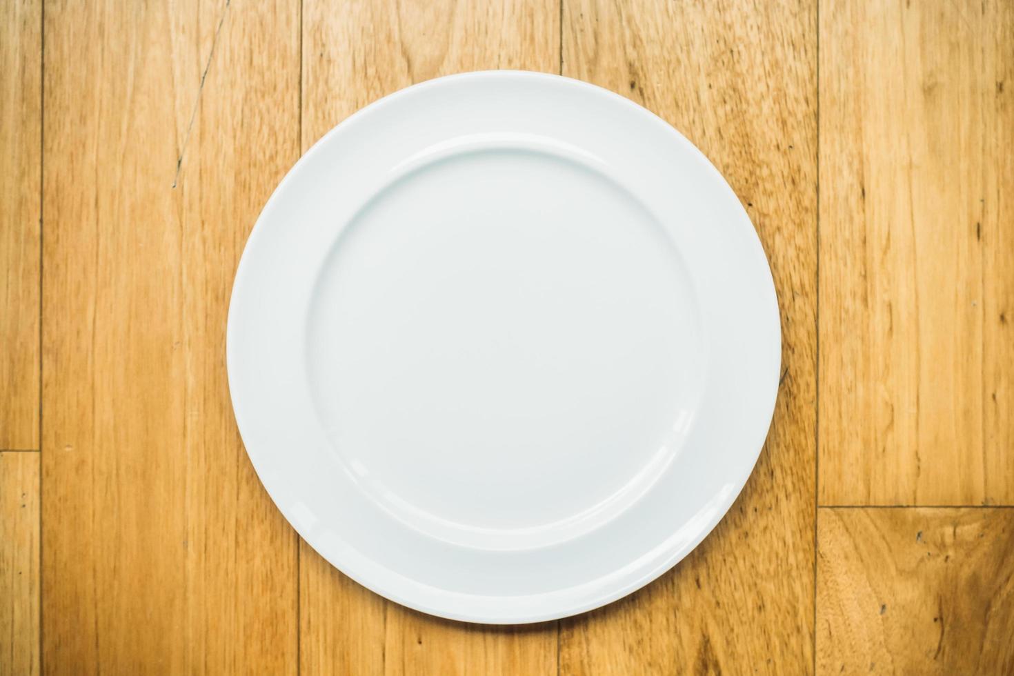 Empty white plate on wooden background photo