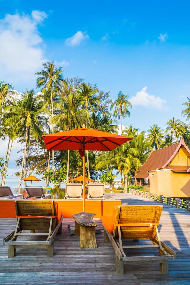 Umbrella and chair around swimming pool photo