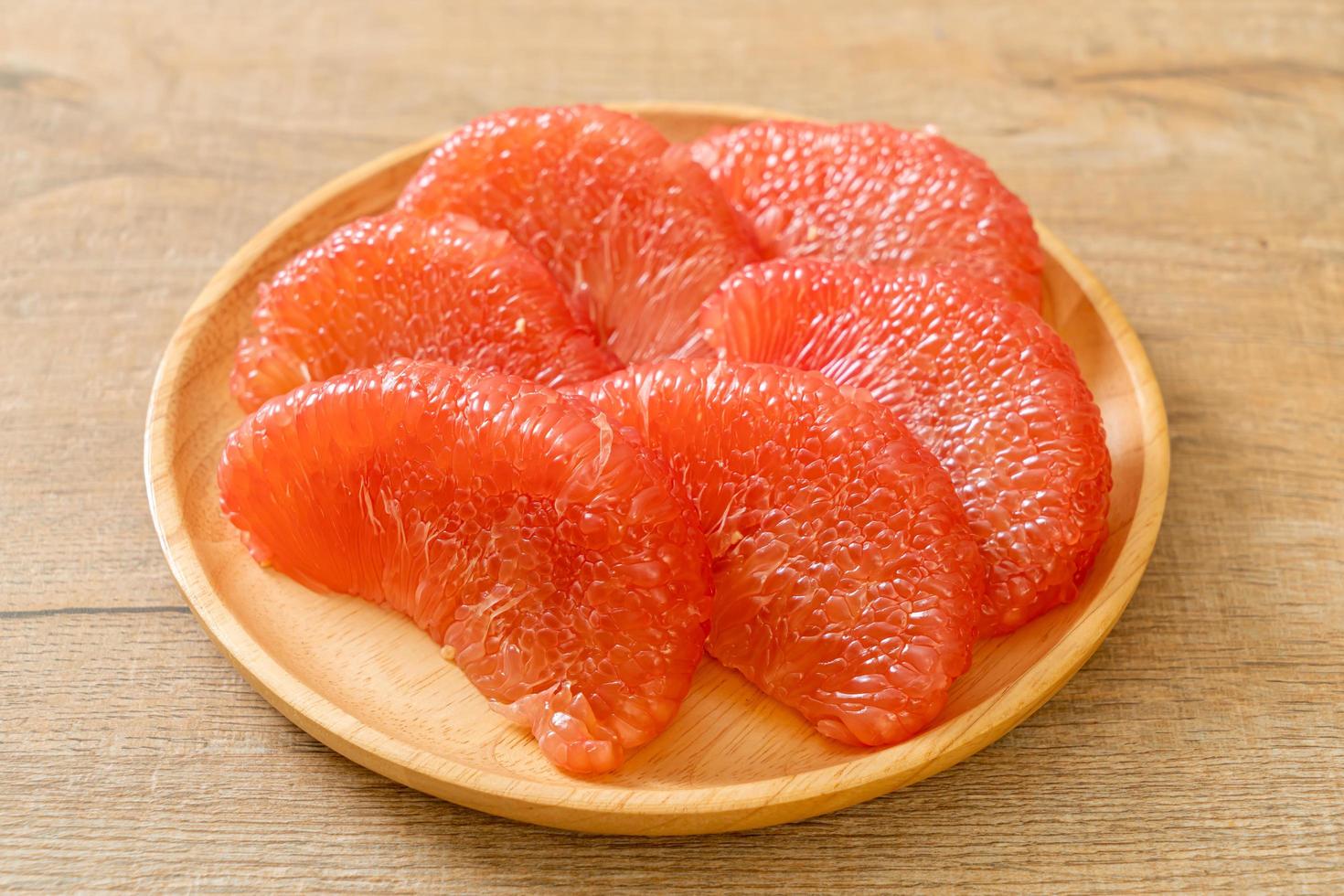 Fresh red pomelo fruit or grapefruit on plate photo