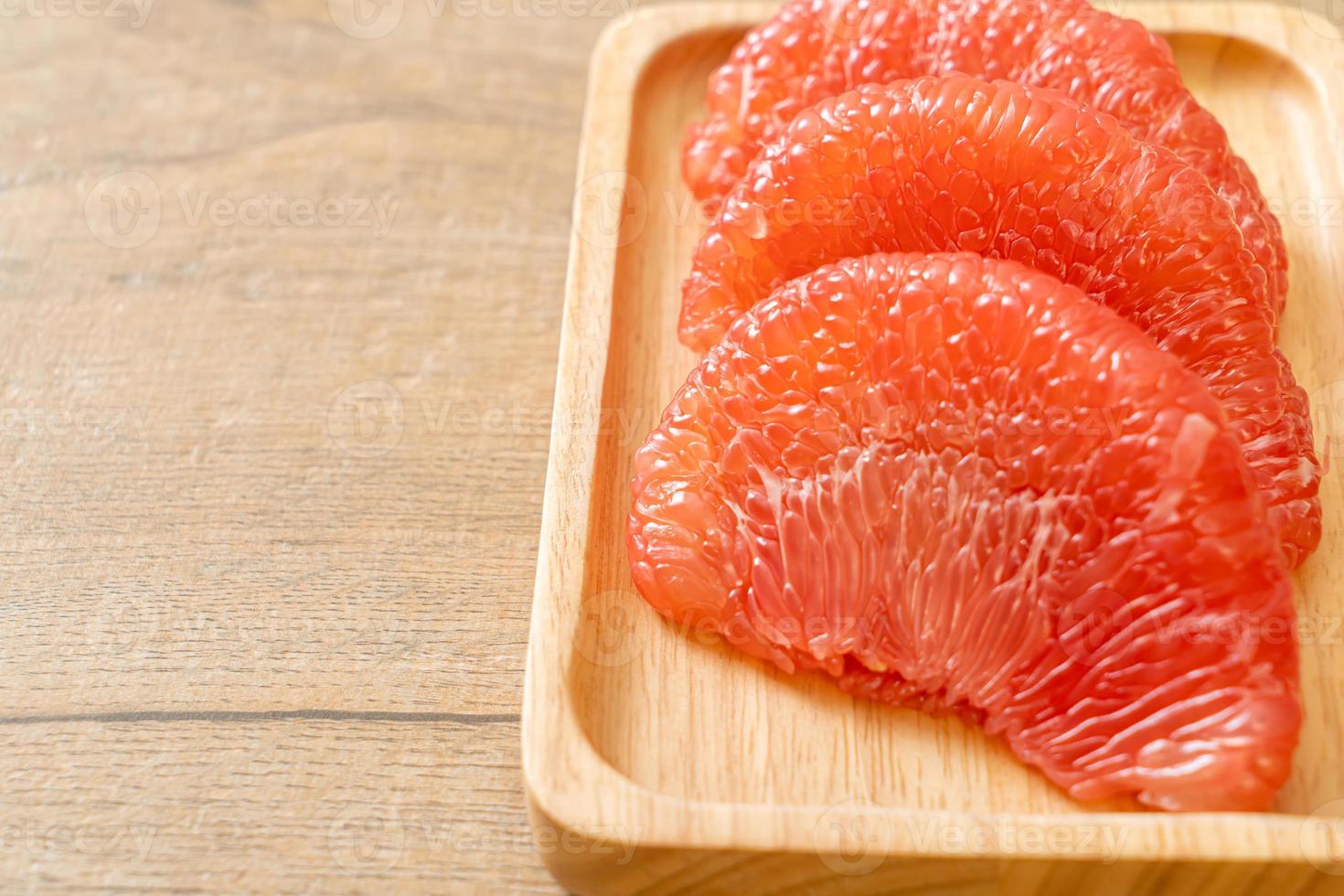 Fresh red pomelo fruit or grapefruit on plate photo