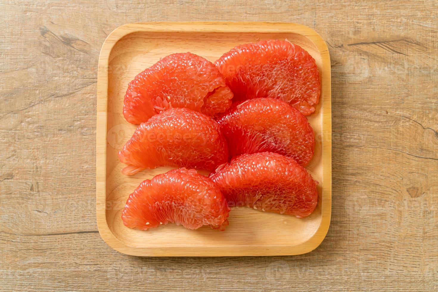 Fresh red pomelo fruit or grapefruit on plate photo