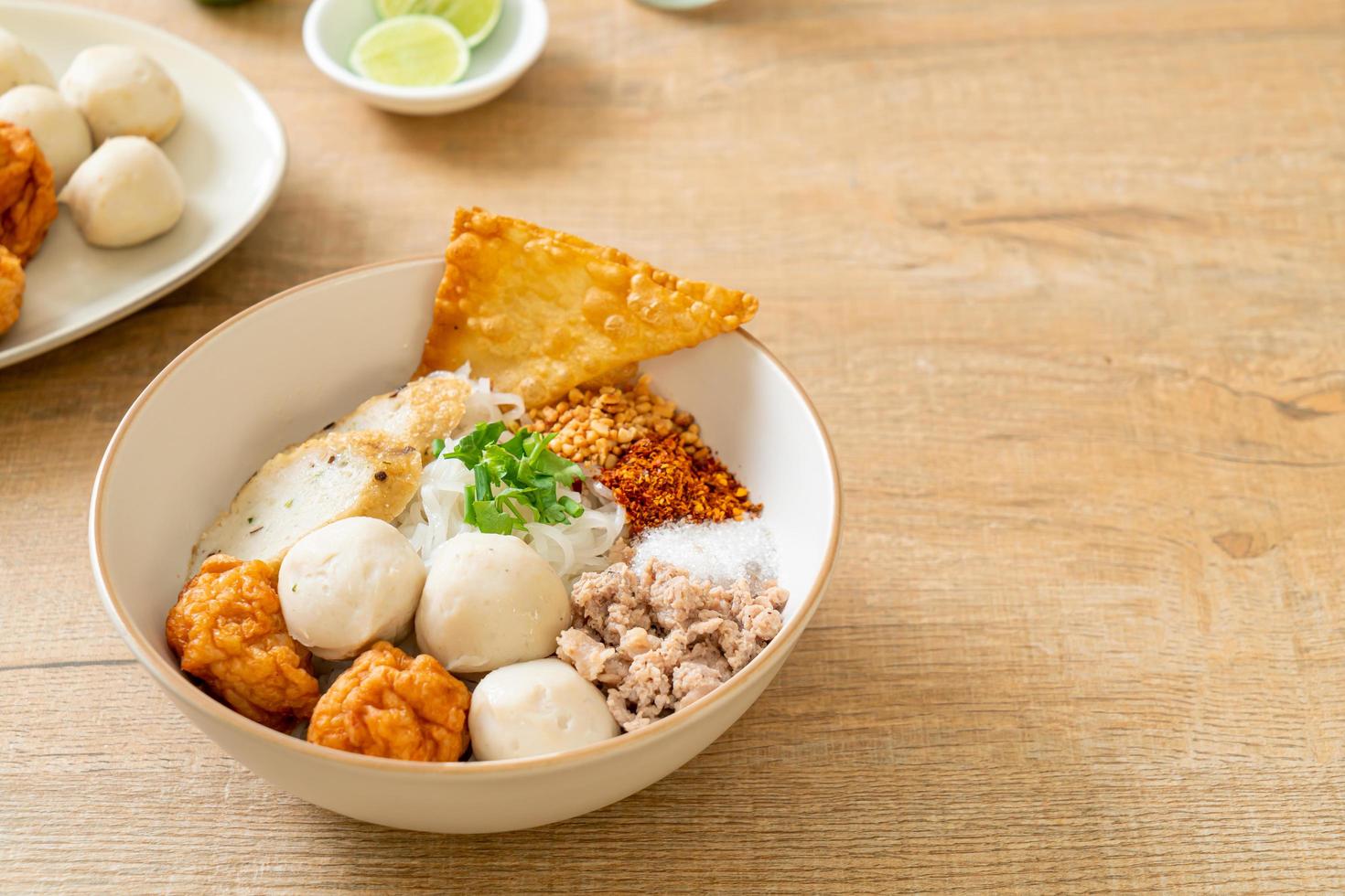 Spicy small flat rice noodles with fish balls and shrimp balls without soup - Asian food style photo