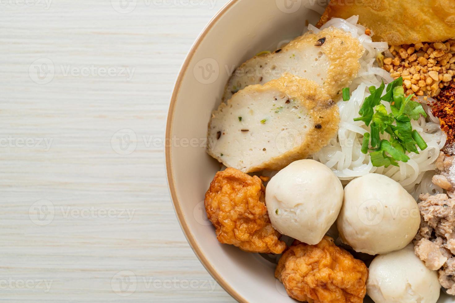 Fideos de arroz planos pequeños picantes con bolas de pescado y bolas de camarones sin sopa - estilo de comida asiática foto