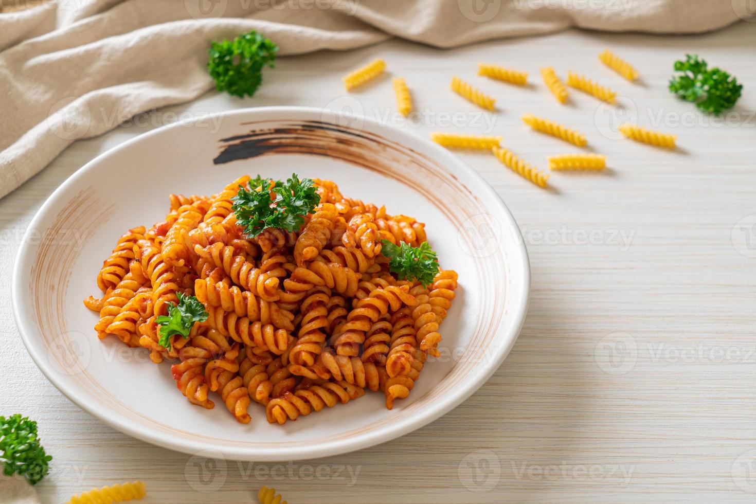 pasta en espiral o spirali con salsa de tomate y salchicha - estilo de comida italiana foto