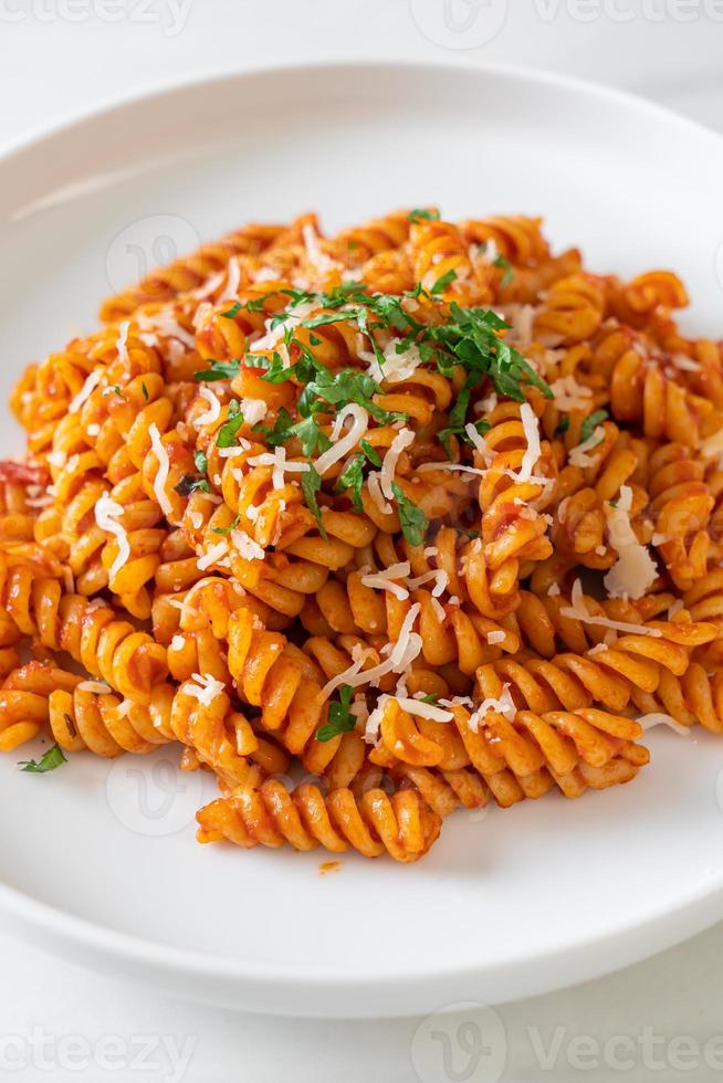 Spiral or spirali pasta with tomato sauce and sausage - Italian food style photo