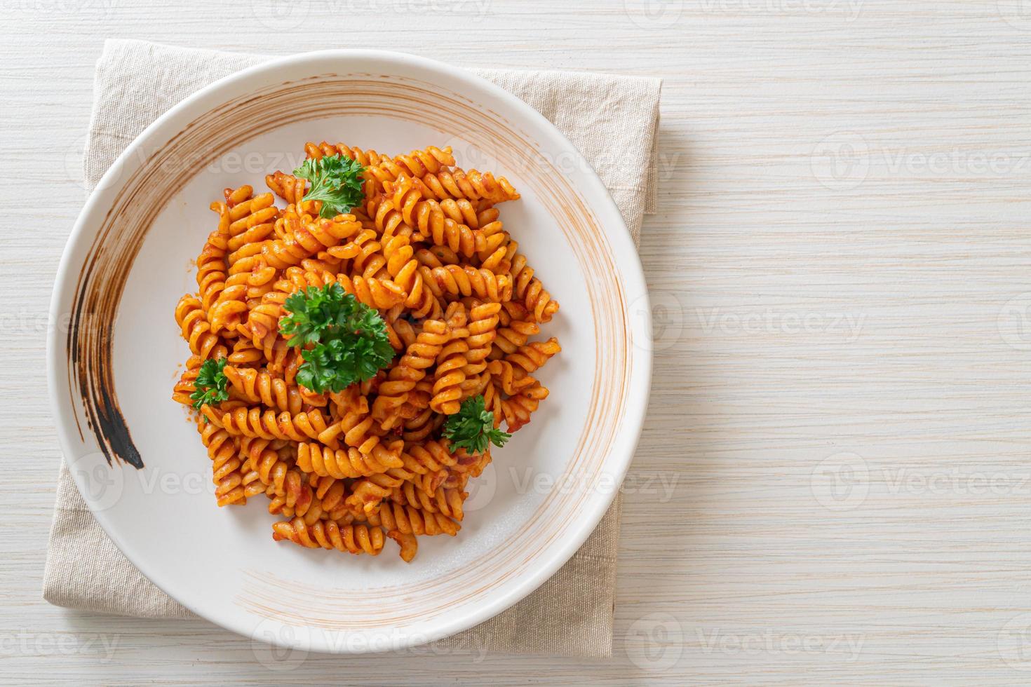 pasta en espiral o spirali con salsa de tomate y salchicha - estilo de comida italiana foto