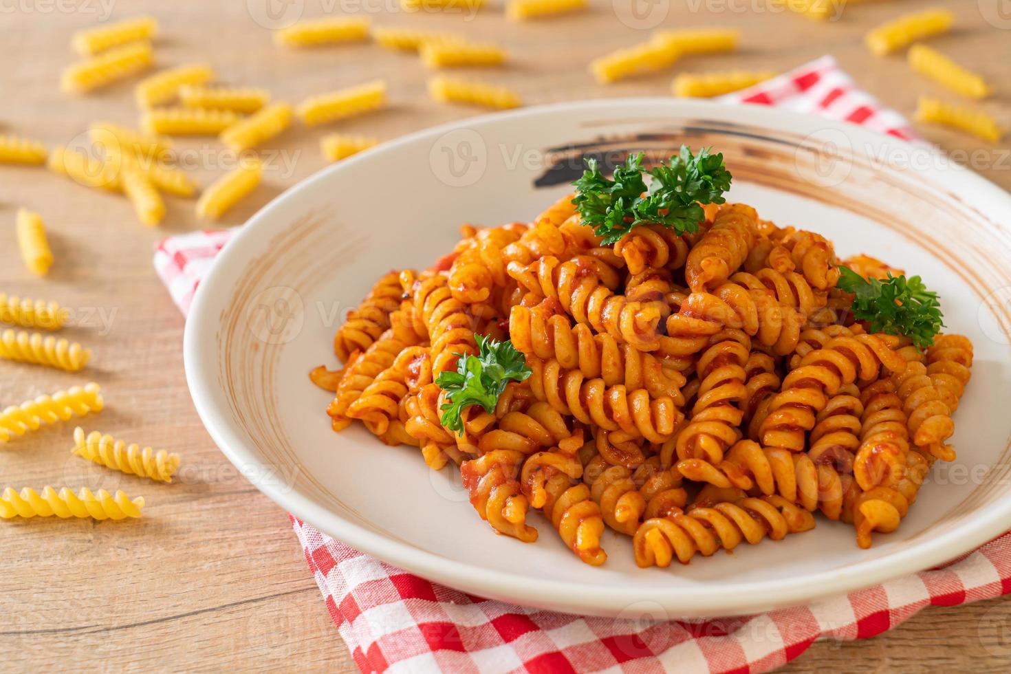 pasta en espiral o spirali con salsa de tomate y salchicha - estilo de comida italiana foto