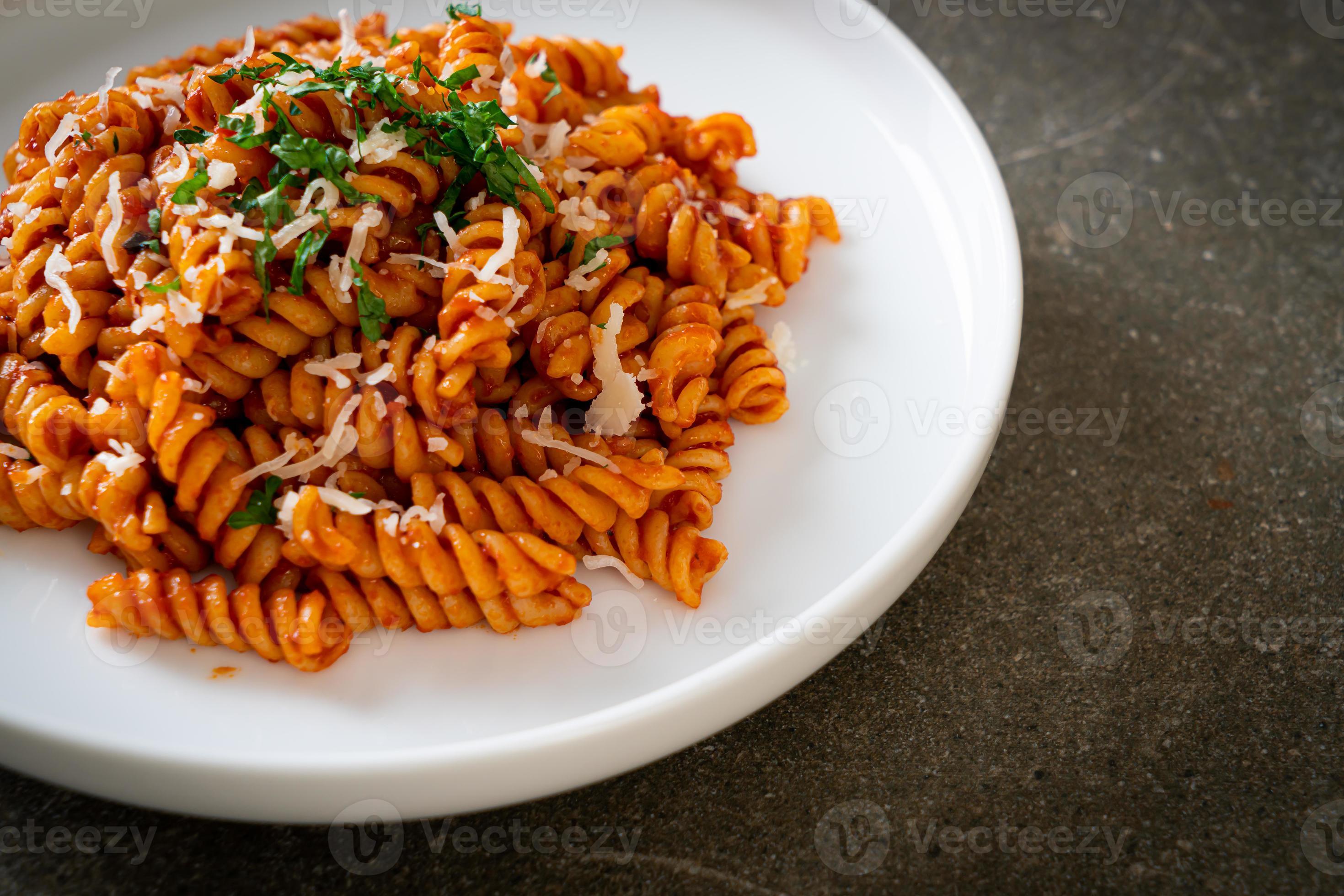 pasta en espiral o spirali con salsa de tomate y salchicha - estilo de comida italiana foto