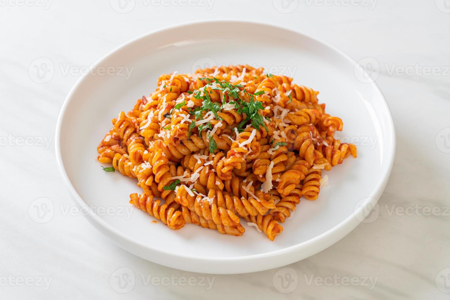 pasta en espiral o spirali con salsa de tomate y salchicha - estilo de comida italiana foto