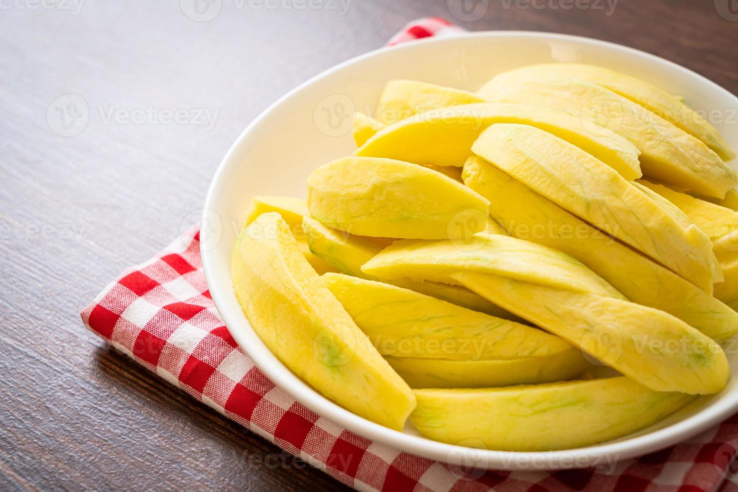 Fresh green and golden mango sliced on plate photo