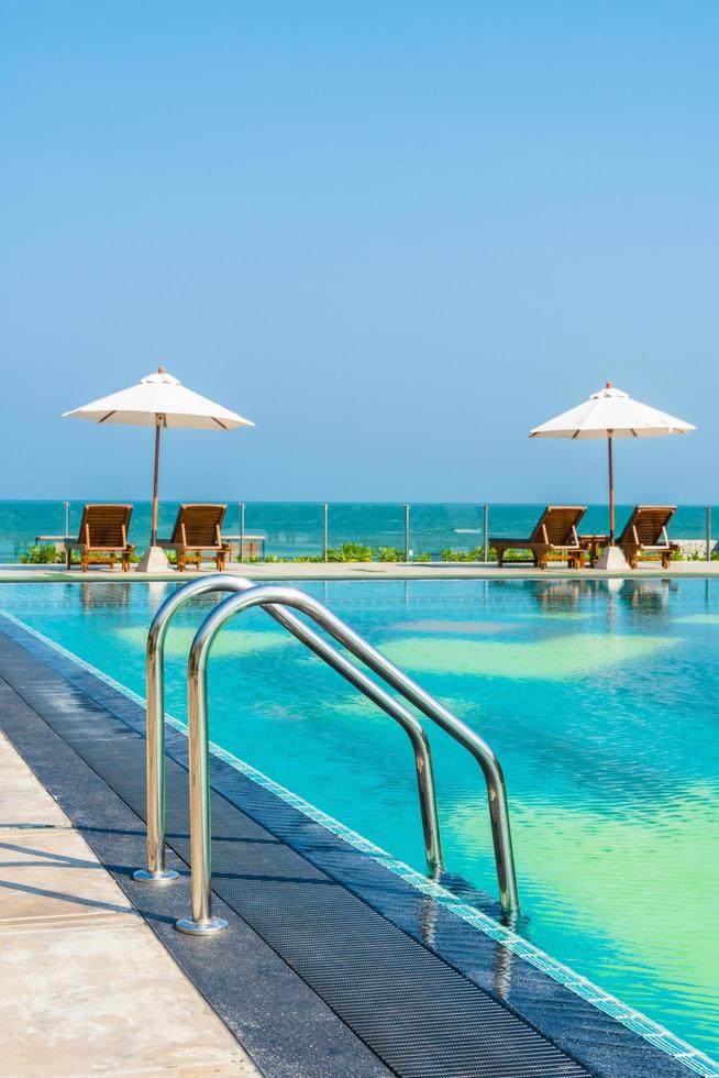 Beautiful umbrella and chair around swimming pool in hotel and resort photo