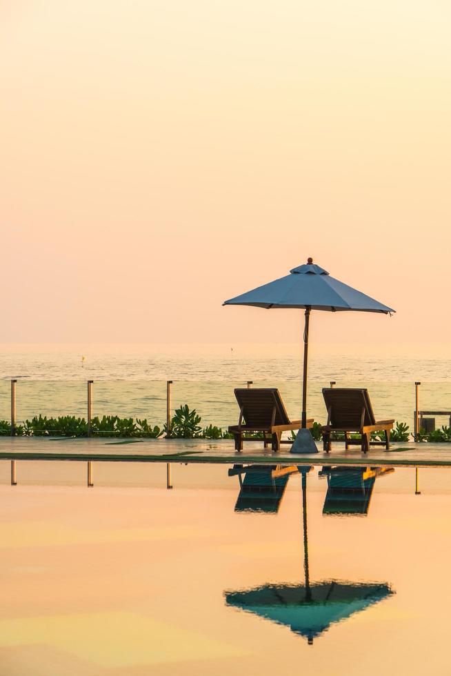 Beautiful umbrella and chair around swimming pool in hotel and resort photo