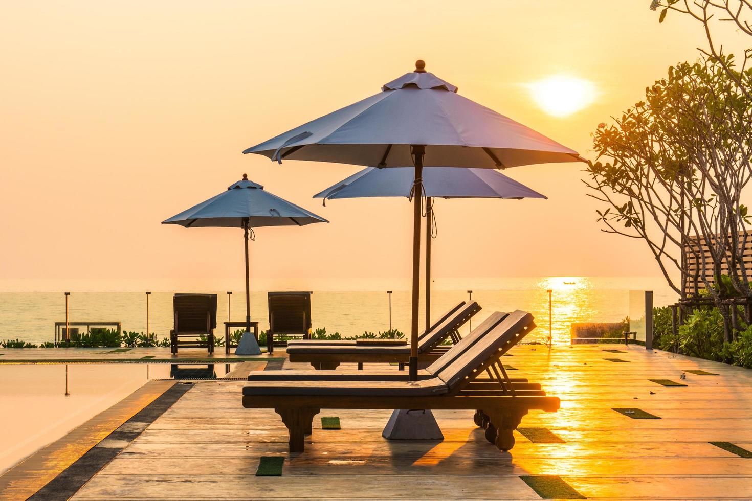 Beautiful umbrella and chair around swimming pool in hotel and resort photo