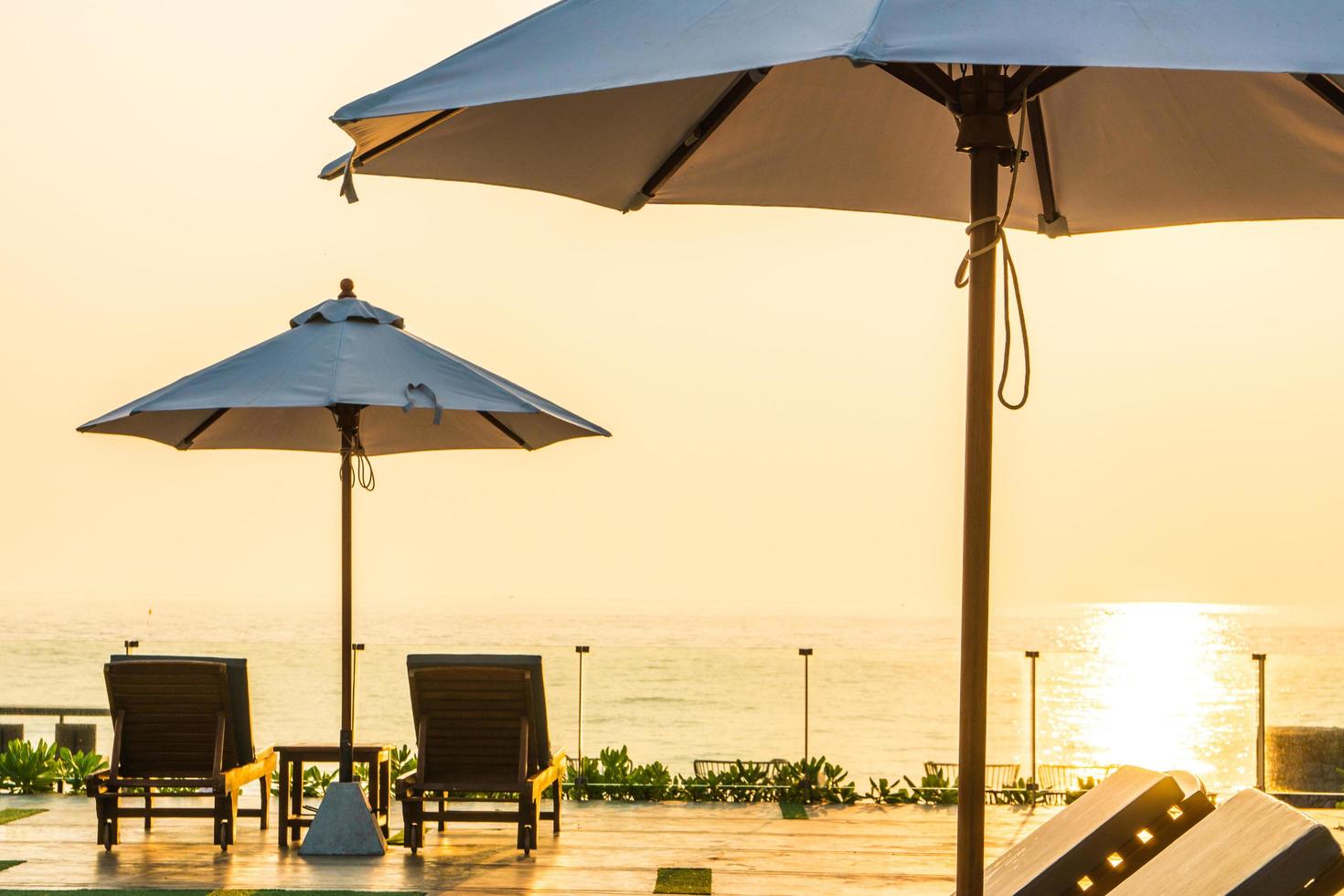 Beautiful umbrella and chair around swimming pool in hotel and resort photo