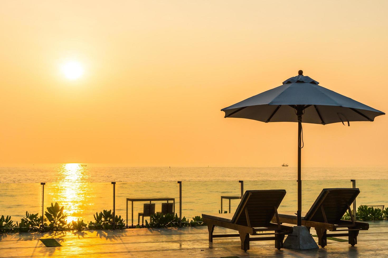 Beautiful umbrella and chair around swimming pool in hotel and resort photo