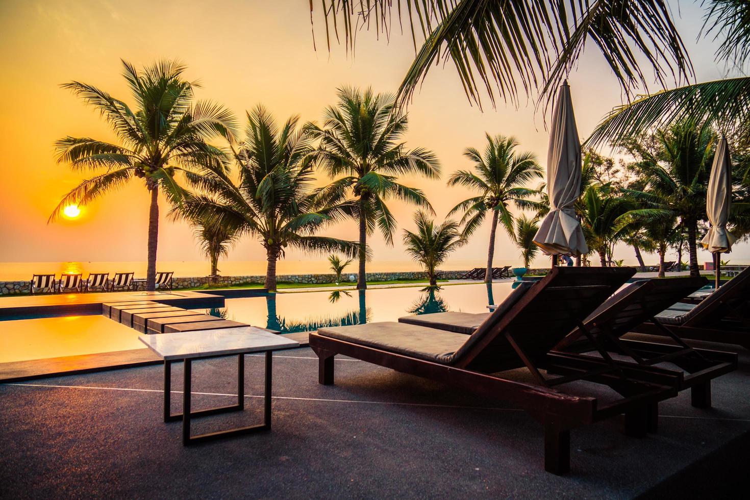 Silueta de palmera de coco alrededor de la piscina al aire libre foto