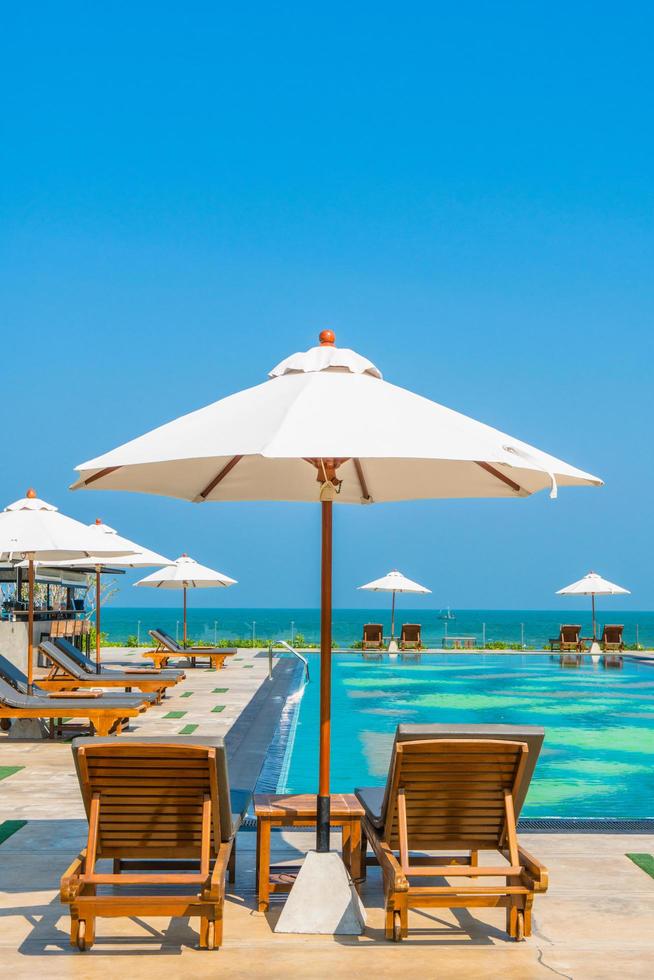 Beautiful umbrella and chair around swimming pool in hotel and resort photo