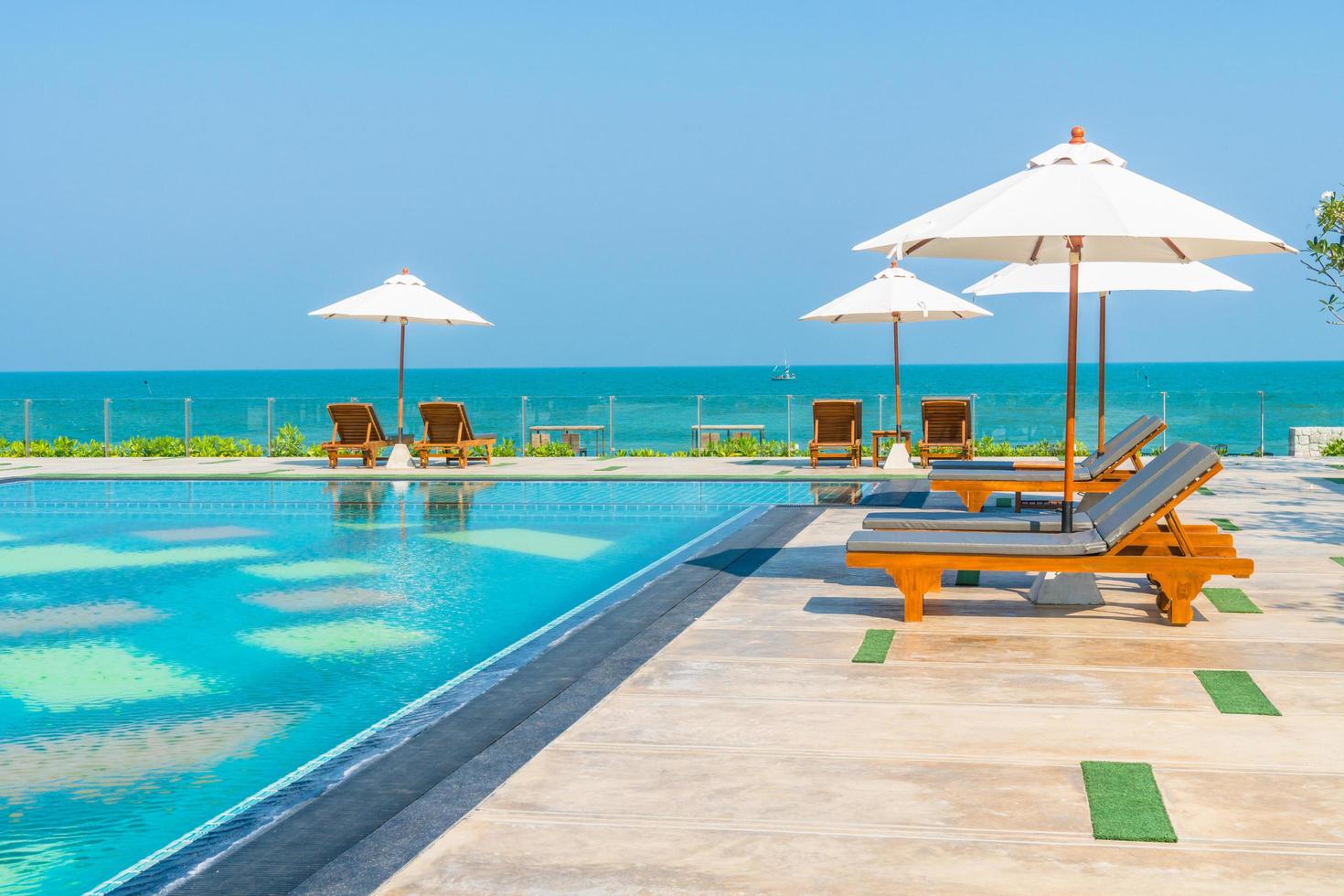 Beautiful umbrella and chair around swimming pool in hotel and resort photo