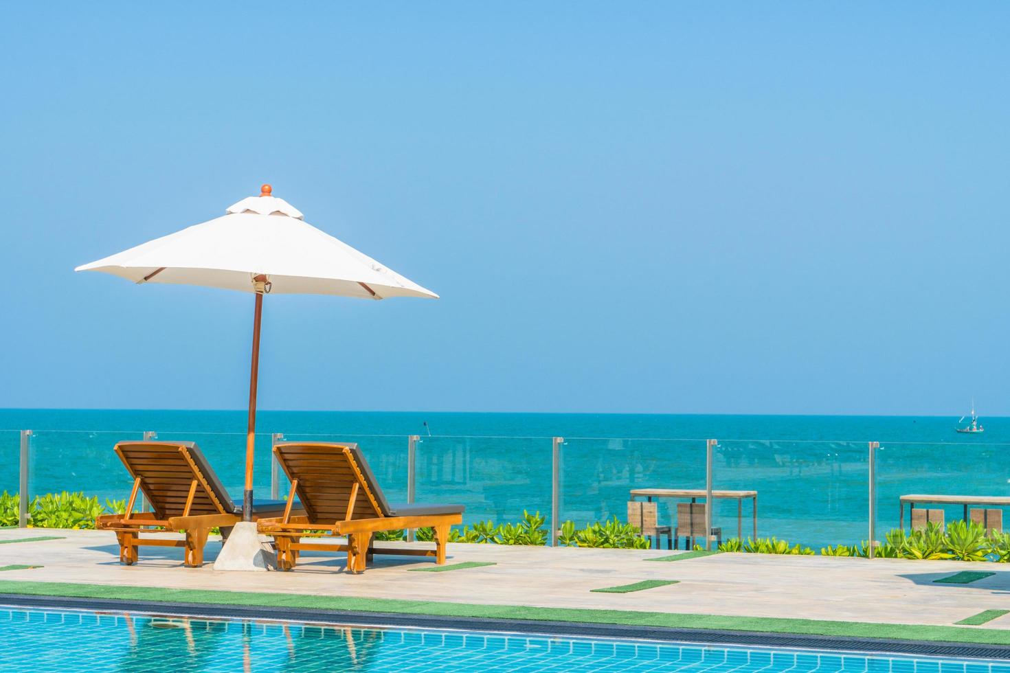 Beautiful umbrella and chair around swimming pool in hotel and resort photo