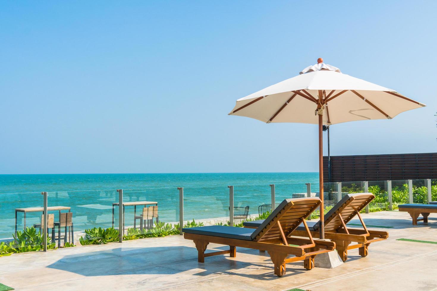 Beautiful umbrella and chair around swimming pool in hotel and resort photo