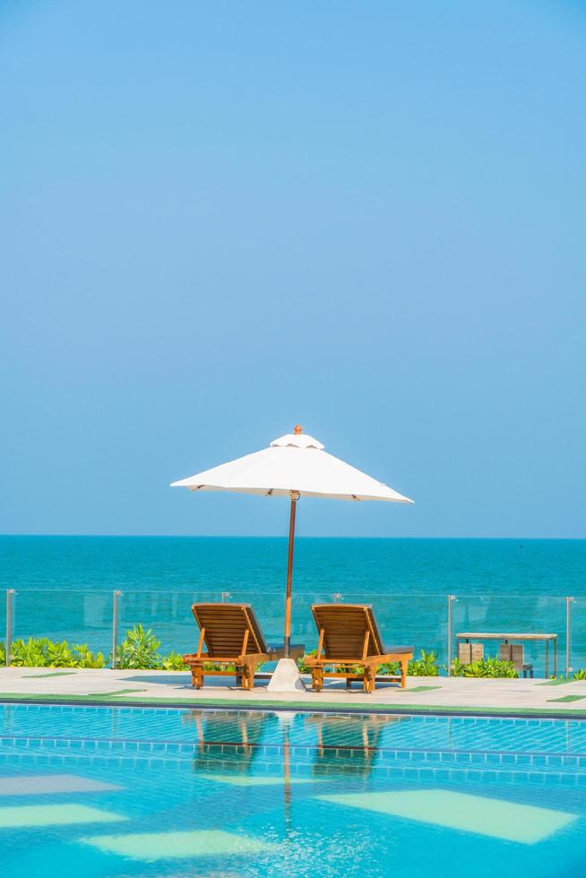 Beautiful umbrella and chair around swimming pool in hotel and resort photo